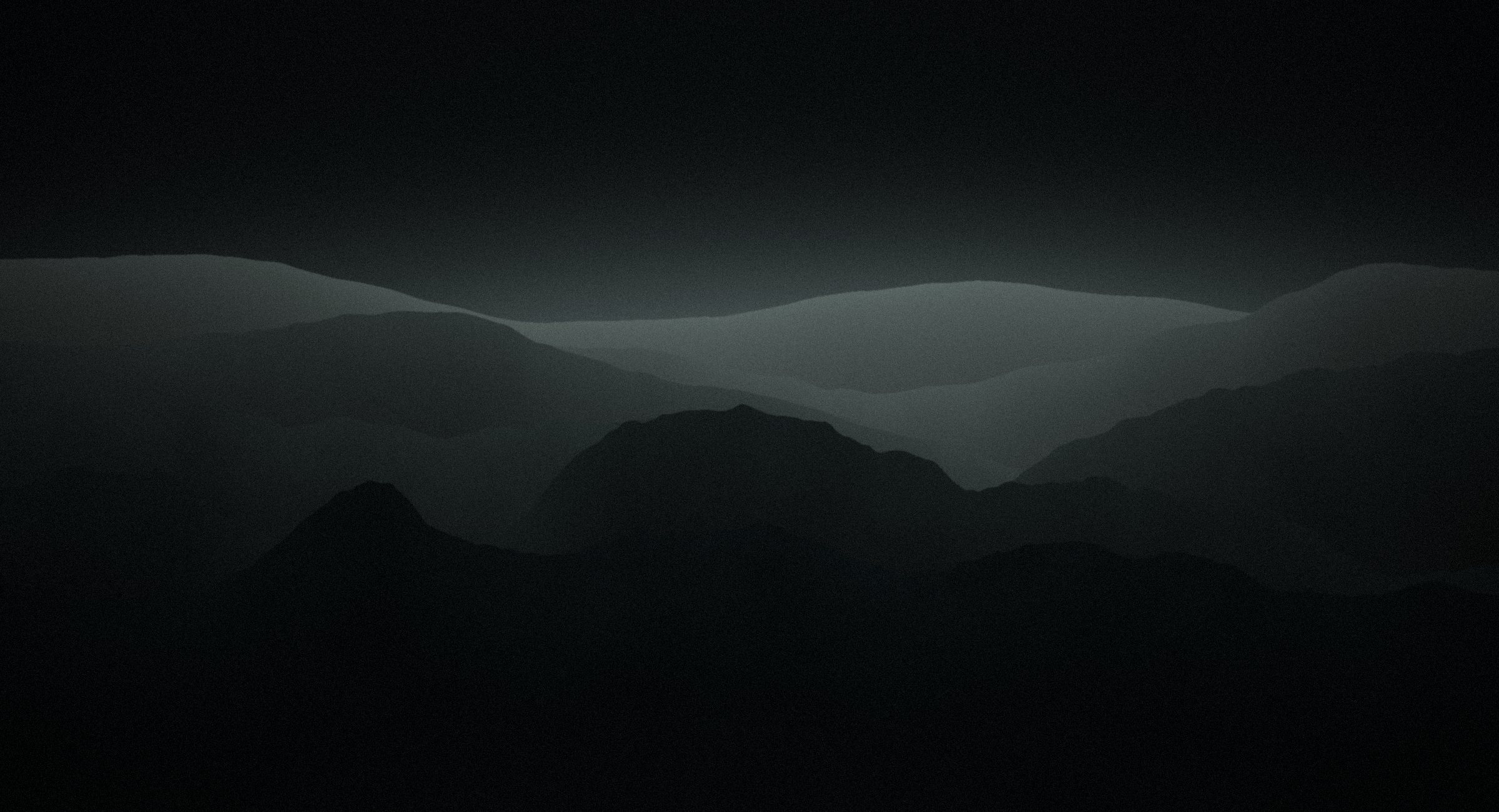Layered mountain ridges in low light